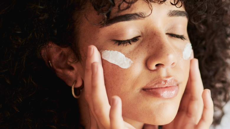 woman applying sunscreen to face