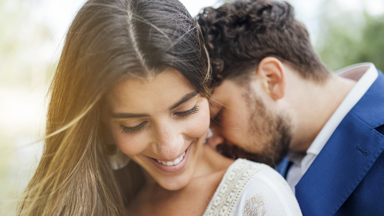 Man nuzzling woman's neck