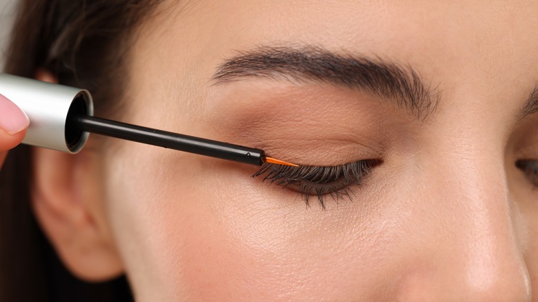 Woman applying lash serum