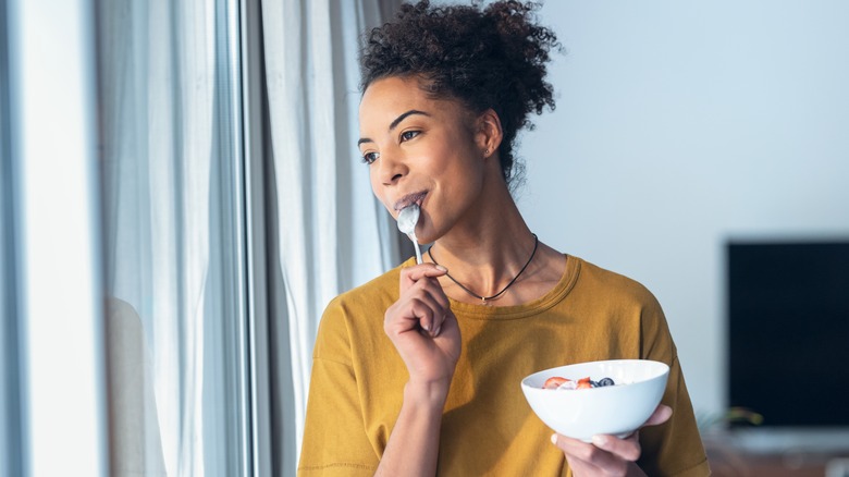 Woman eating yogurt and berries