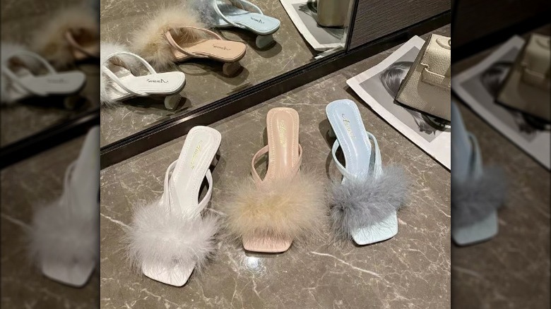 Fur tufted thong sandals on marble floor 