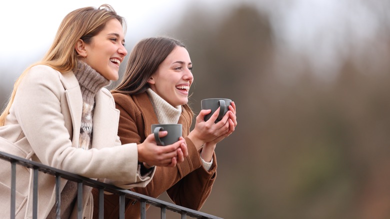 Couple standing outside with mugs