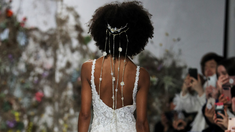 Model wears backless wedding dress