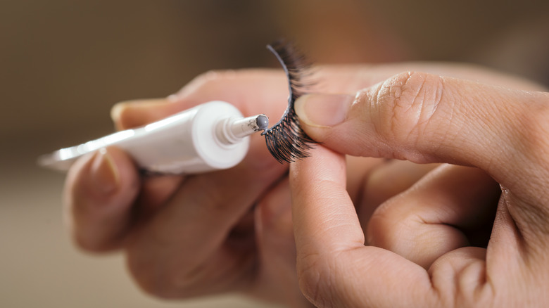 Woman applying glue to false lashes