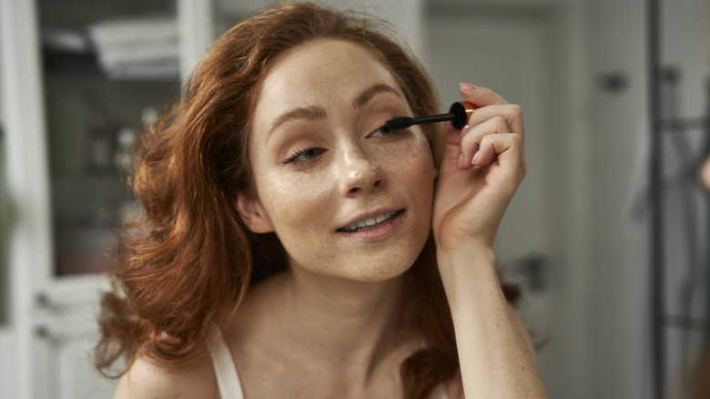 Woman applying mascara