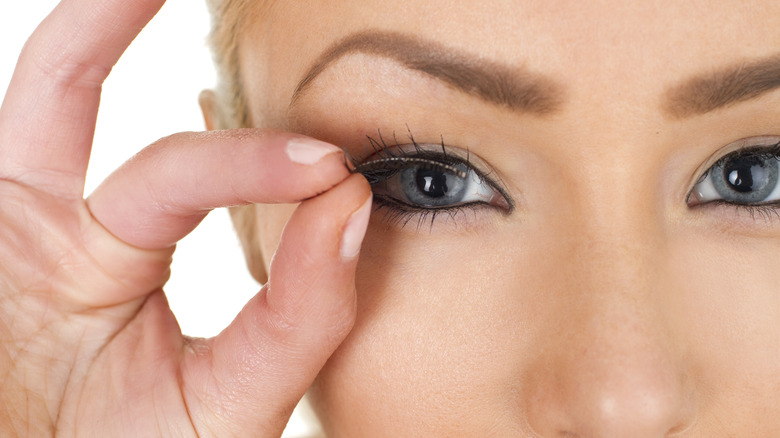 Woman holding up false lashes