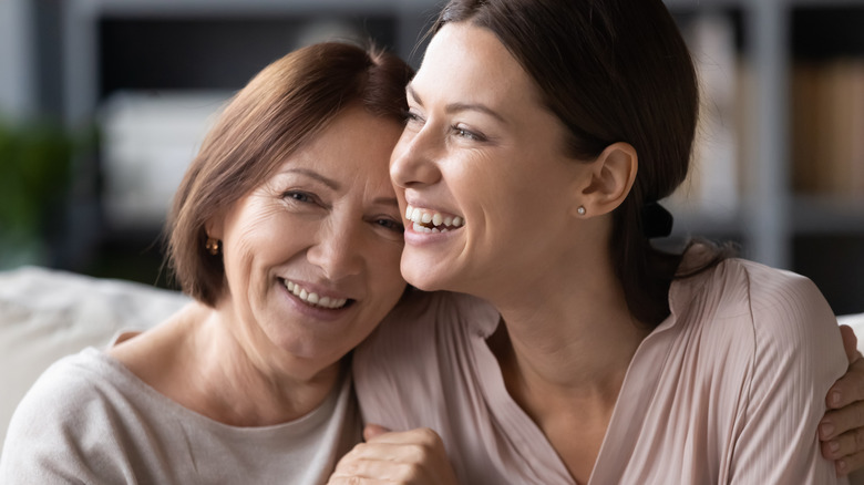 mother and adult daughter smiling