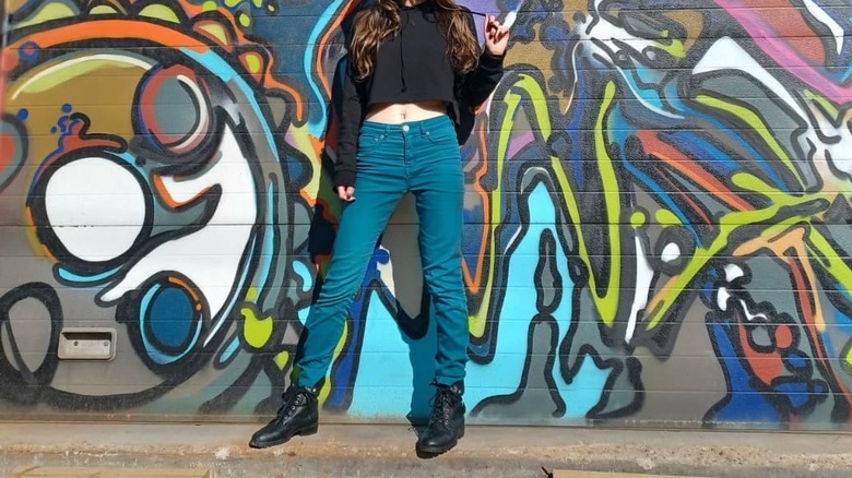 Teal pants, black top and boots