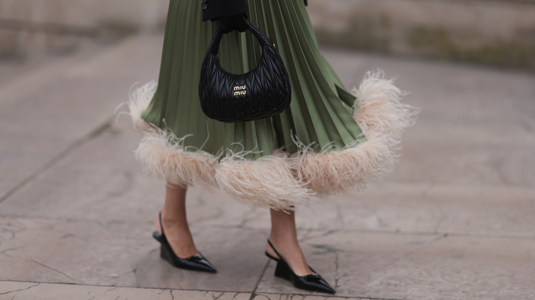 Woman sporting green feather-trimmed skirt