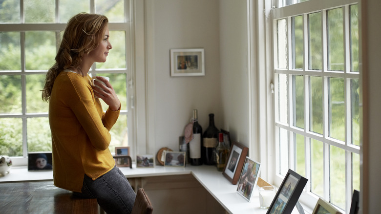 Woman looks out window