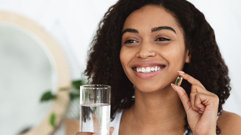 woman about to take supplement