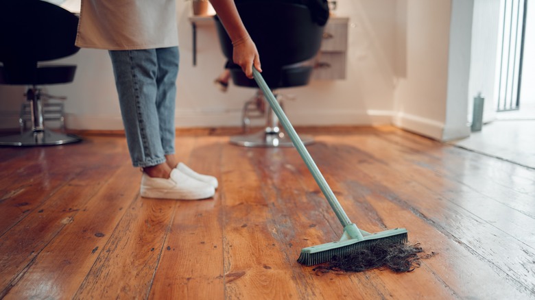 Woman sweeps salon floor