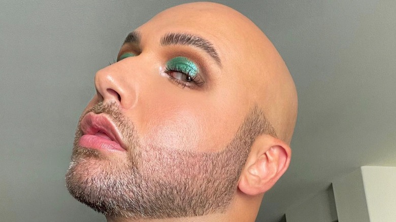 A man with green eyeshadow