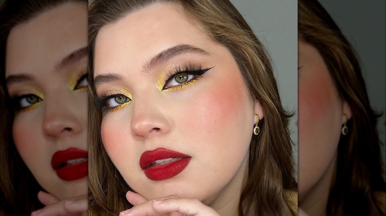 A woman with red lisp and gold eyemakeup