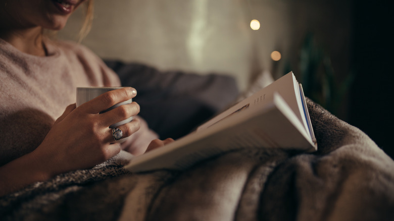 woman with cup reading book