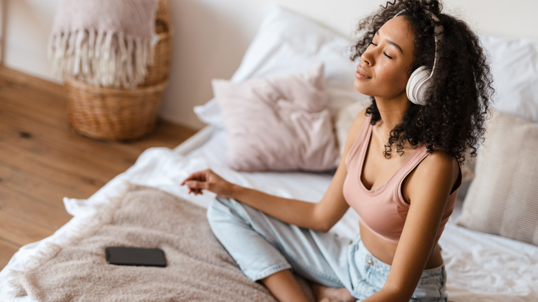 woman cross-legged listening to music