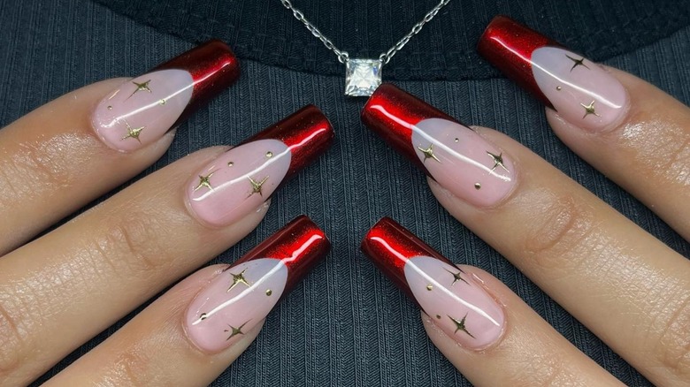 Hands showing red chrome nails