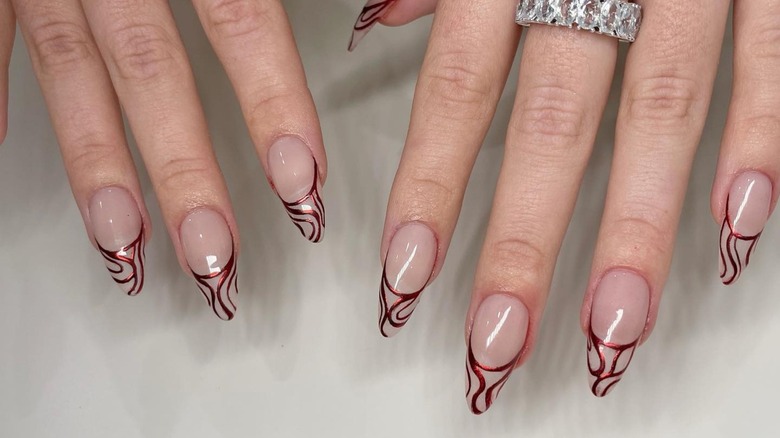 Hands with red chrome graphic nails