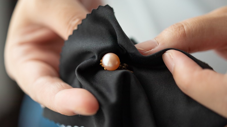 Hands polishing pearl earrings