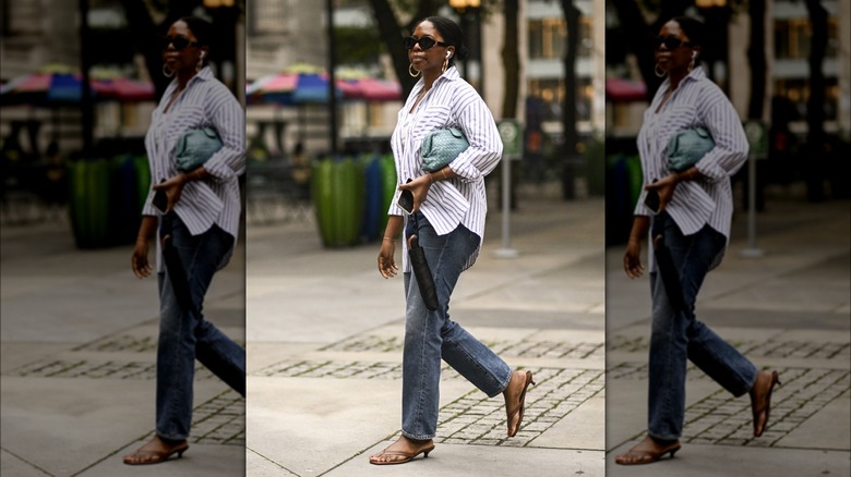 Person in striped shirt, jeans, and flip-flops