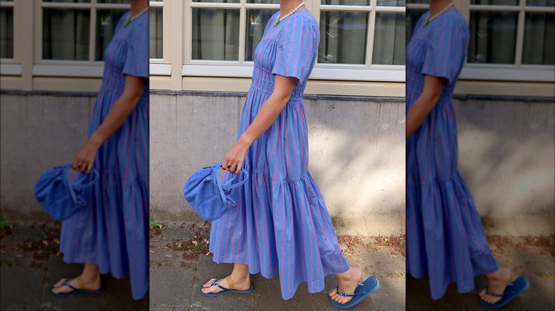 Person in a blue maxi dress and flip-flops