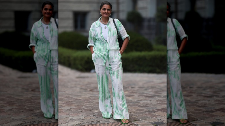 Person in green and white outfit with flip-flops