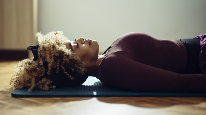 Woman deep breathing yoga mat