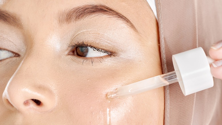 Woman in hijab applying serum