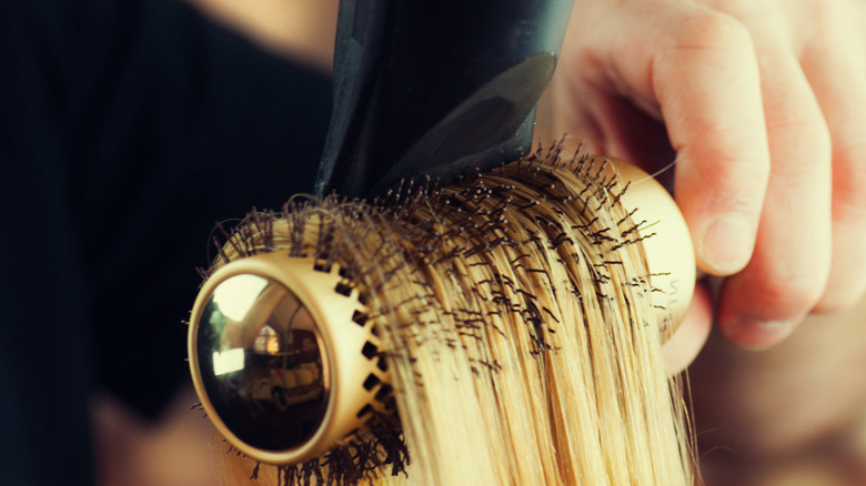 Closeup of hair section being dried with round brush