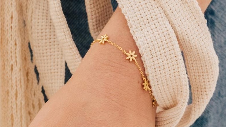 Instagram user @Caitlynminimalist showing gold daisy bracelet