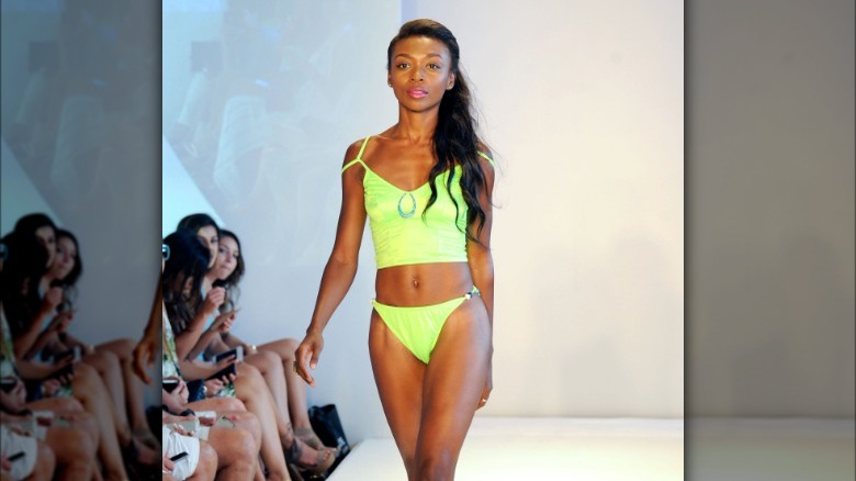 Model wearing lime green tankini swimsuit