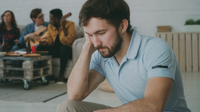 A frowning man sitting alone