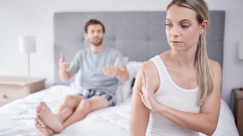 A couple fighting in a bedroom