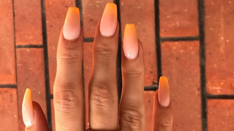 Tangerine fombré nails on hand