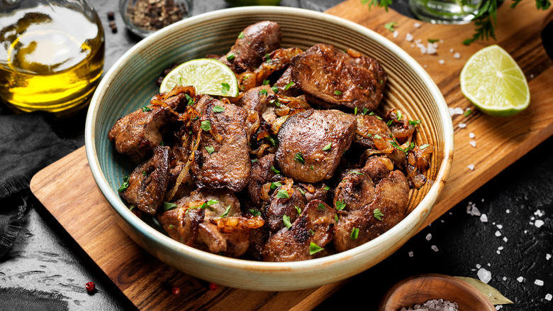 Chicken livers served in bowl atop cutting board