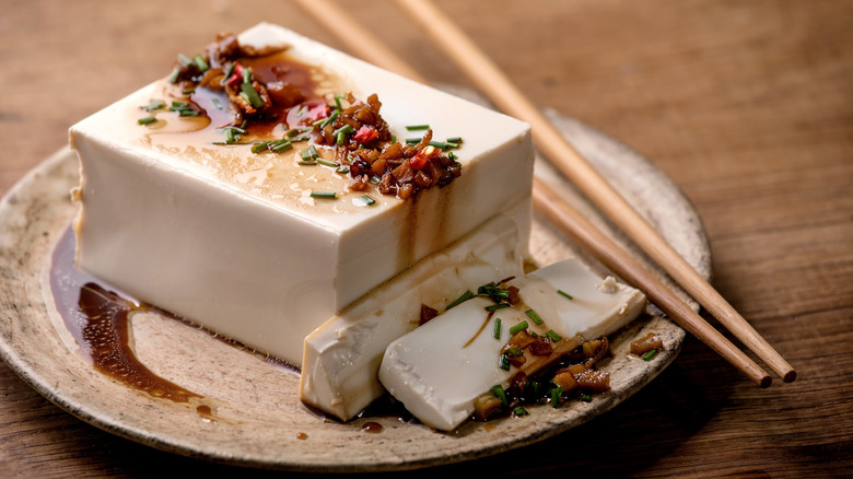 Chilled tofu with garnish next to chopsticks