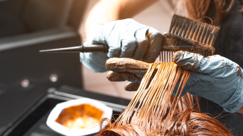 A hairstylist dying a client's hair