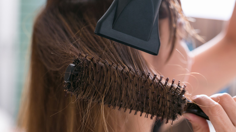 woman blow drying hair 