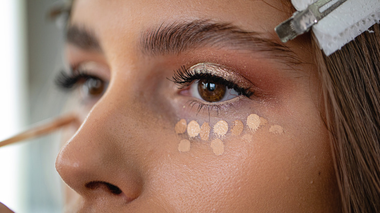 woman using foundation and concealer dots