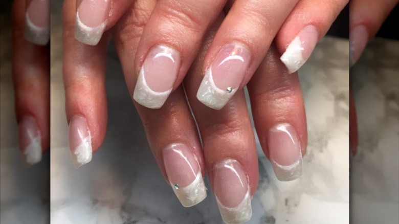 Hand with pearlescent French manicure