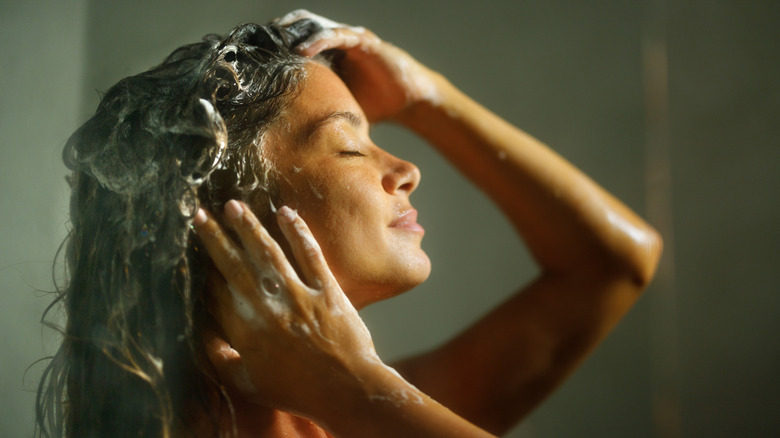 Woman shampooing hair in shower