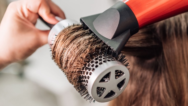 Close-up of person blow drying their hair