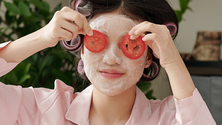 Woman using tomato in skincare