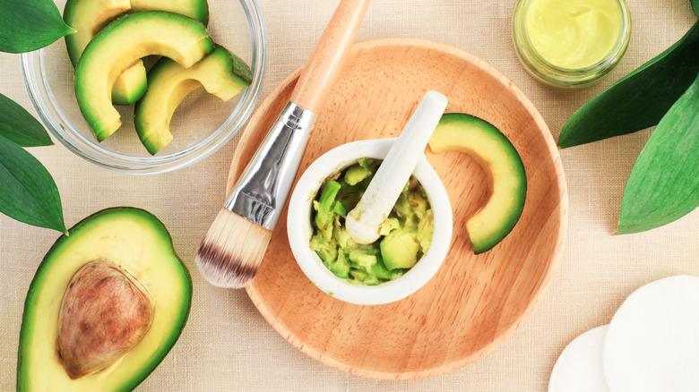 Sliced avocados with skincare utensils