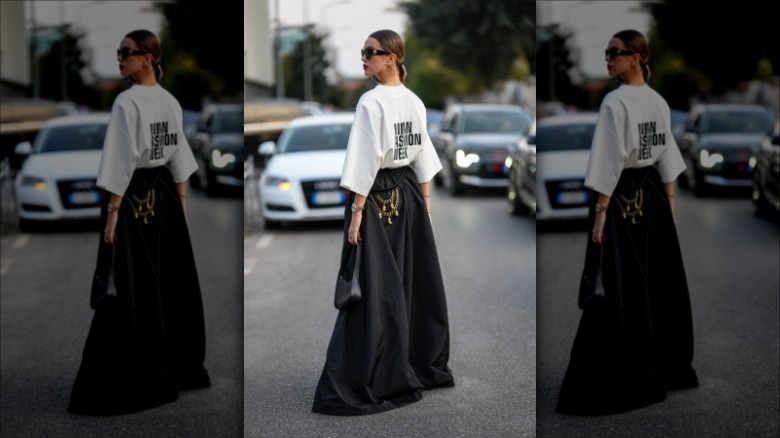 woman wearing a graphic tee and black long full skirt