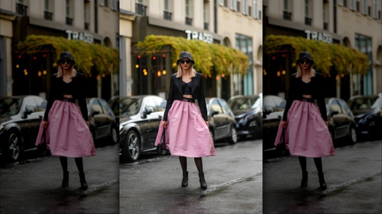 woman wearing a black cropped blazer and pink full skirt