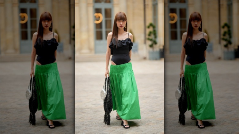 woman wearing a black bodysuit and green full skirt