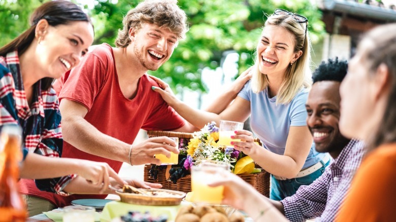 Young adults sharing drinks outside