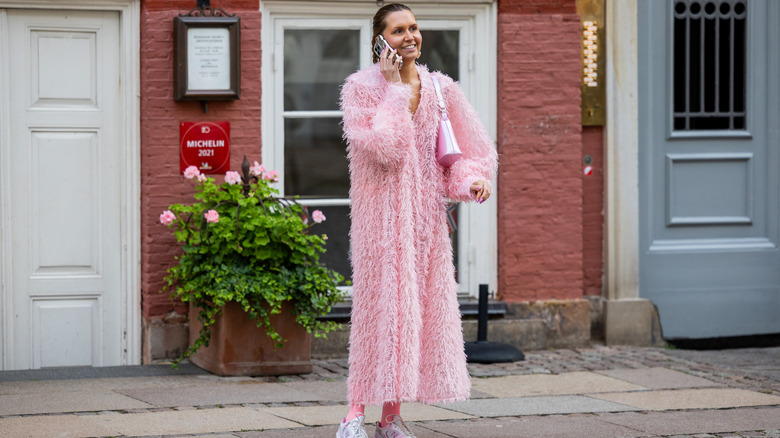 woman wearing feathered maxi coat