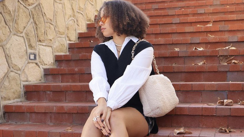 woman with full hair sitting on stairs